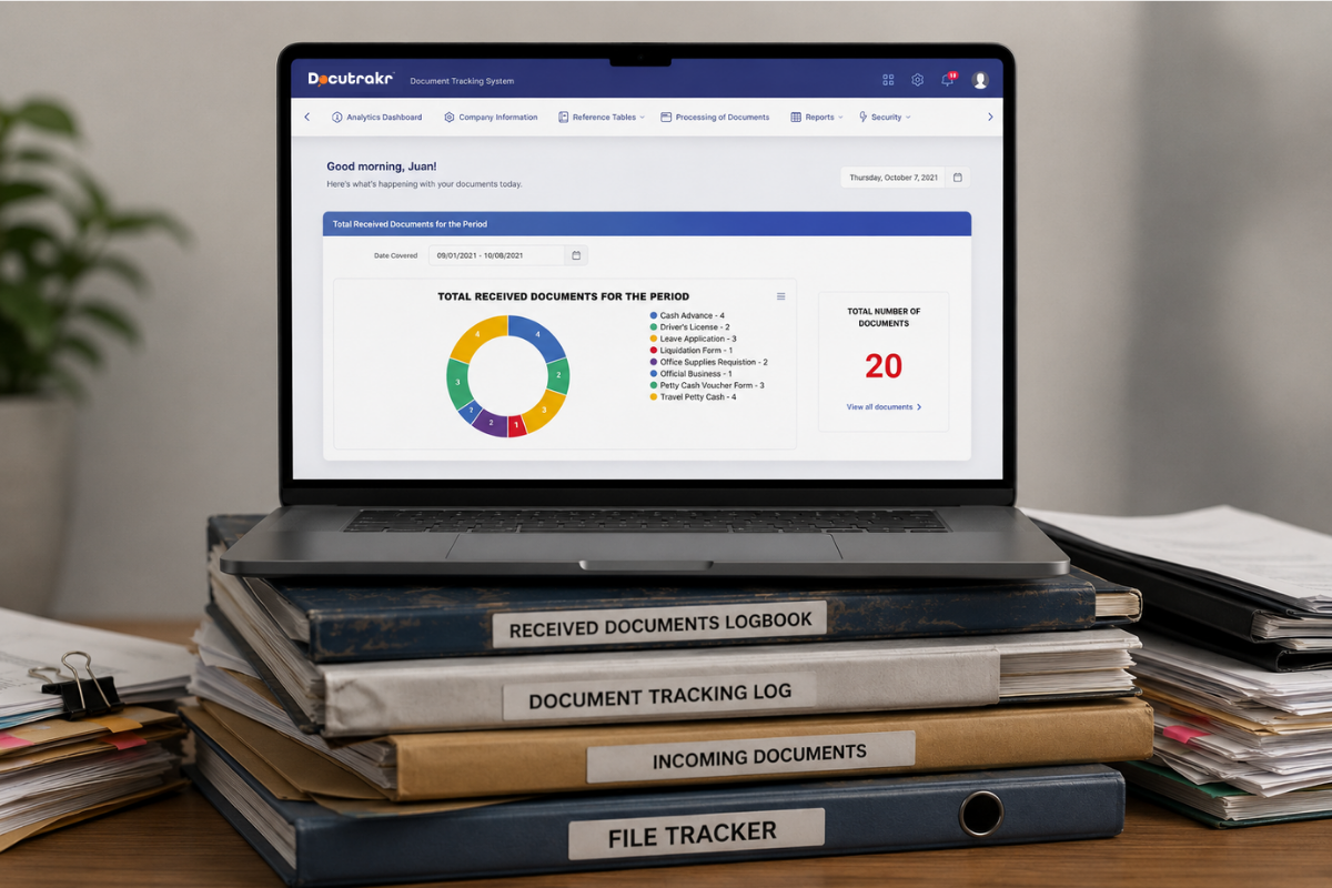 Docutrakr dashboard shown on a laptop atop stacked document logbooks